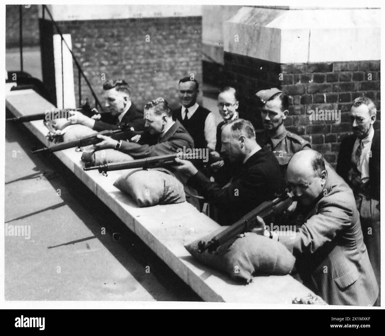 Le personnel de la police civile participe à des exercices de tir sous la supervision de l'armée britannique, faisant preuve d'une formation au maniement des armes et au tir. Banque D'Images