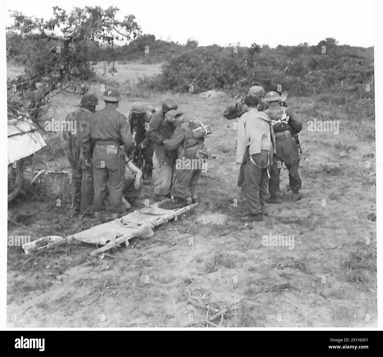 Des parachutistes ennemis blessés sont fouillés par l'armée britannique pendant l'offensive Anzio, documentant les procédures militaires et les opérations sur le champ de bataille. Banque D'Images