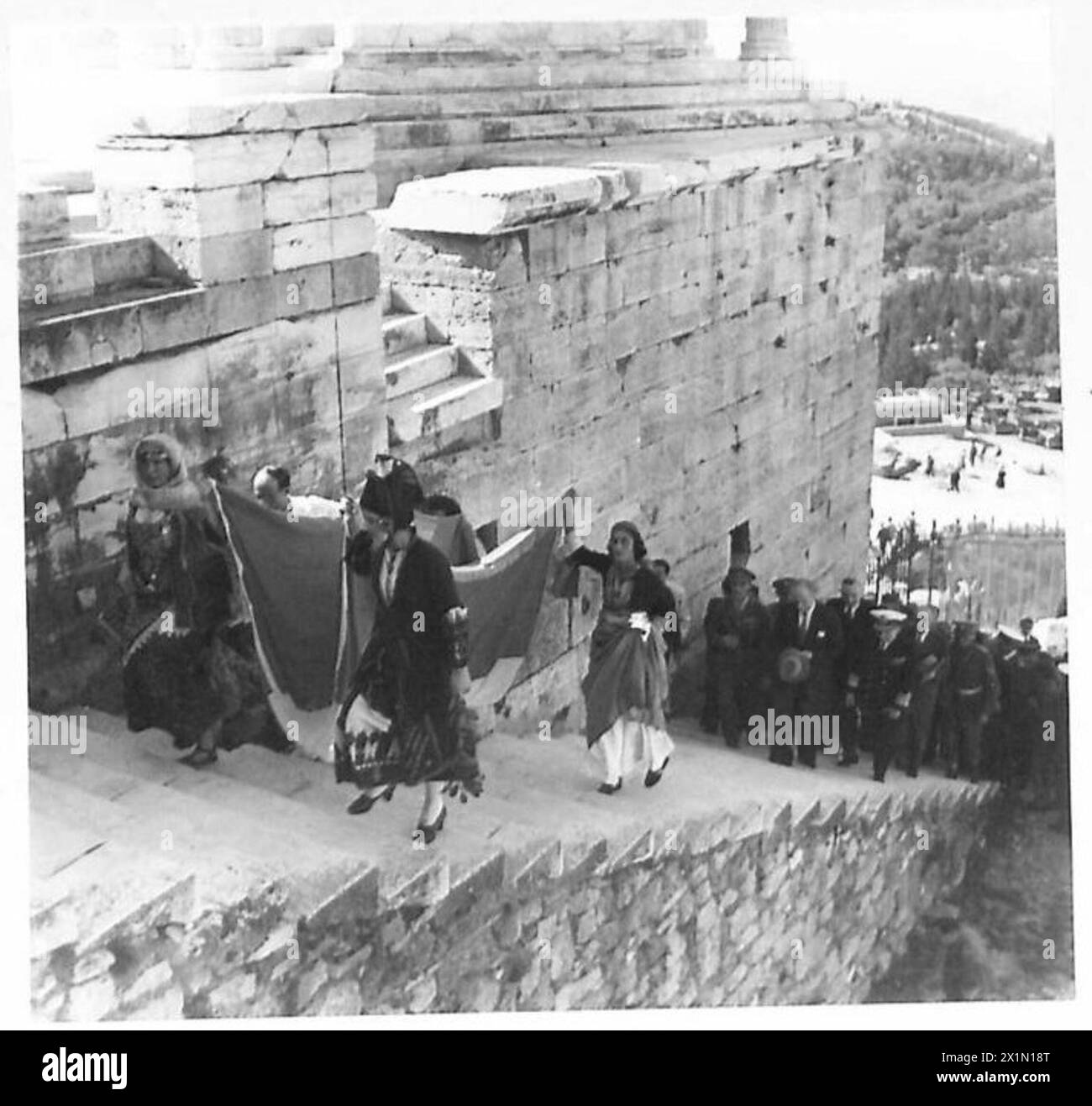 Les filles grecques en costume national portent le drapeau grec jusqu'à l'Acropole pour l'élever au-dessus du Parthénon, armée britannique. Banque D'Images