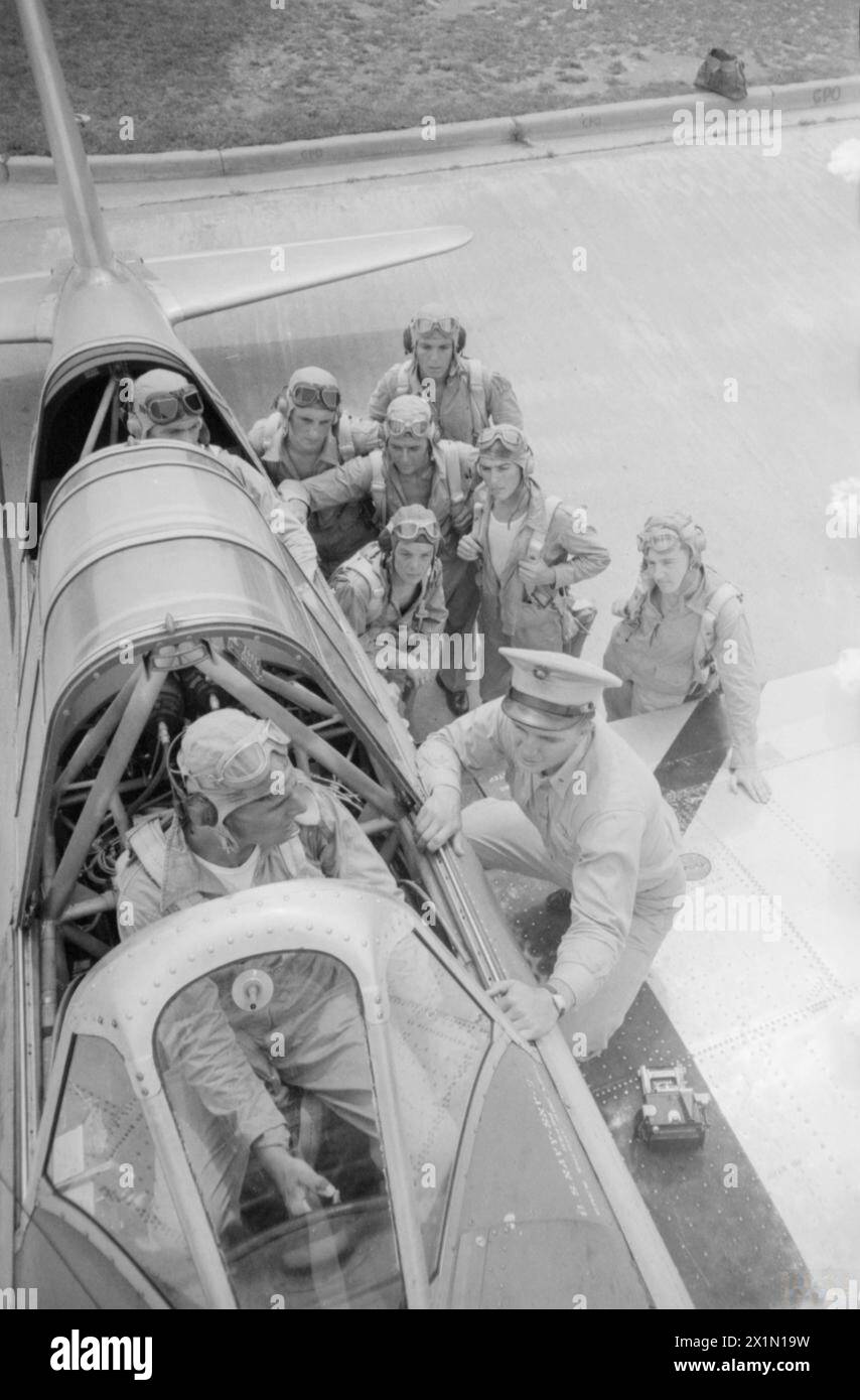 LES PILOTES DE LA MARINE BRITANNIQUE S'ENTRAÎNENT EN AMÉRIQUE POUR LA GUERRE CONTRE LE JAPON. NOVEMBRE 1944, ÉTATS-UNIS. PLUSIEURS CENTAINES DE PILOTES NAVALS BRITANNIQUES DE LA FLOTTE AÉRIENNE SE SONT ENTRAÎNÉS EN AMÉRIQUE CÔTE À CÔTE AVEC DES CADETS AMÉRICAINS POUR SERVIR DANS LES OCÉANS PACIFIQUE ET INDIEN. SOUS LE COMMANDEMENT D'INSTRUCTEURS AMÉRICAINS, ILS SUIVENT D'ABORD UNE FORMATION AÉRIENNE PRIMAIRE DE LA NAVY À BUNKER HILL, INDIANA, PUIS SE RENDENT À PENSACOLA, JACKSONVILLE ET FORT LAUDERDALE, TOUS DANS L'ÉTAT DE FLORIDE. À CE STADE, ILS PARTENT POUR LE MAINE, OÙ À BRUNSWICK ET LEWISTON, ILS SONT CONVERTIS AUX MÉTHODES BRITANNIQUES ET ONT DES EXERCICES D'ATTERRISSAGE SUR PONT, JUSQU'AU JOUR VENU FO Banque D'Images