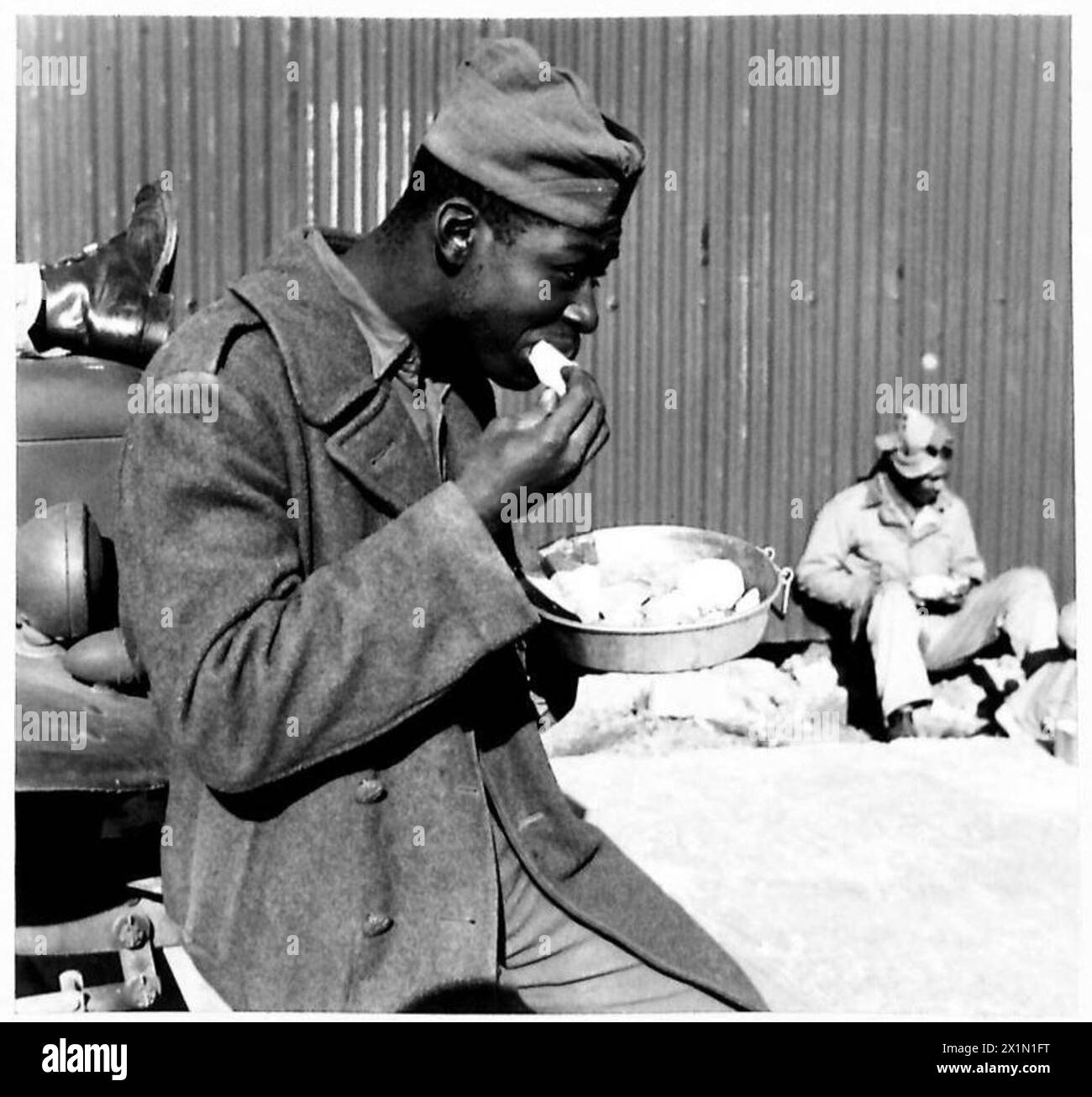 DÉPÔT D'APPROVISIONNEMENT GÉNÉRAL POUR LES MAGASINS ET L'ÉQUIPEMENT AMÉRICAINS - soldats noirs américains travaillant au dépôt mangeant leur repas de midi, l'armée britannique Banque D'Images