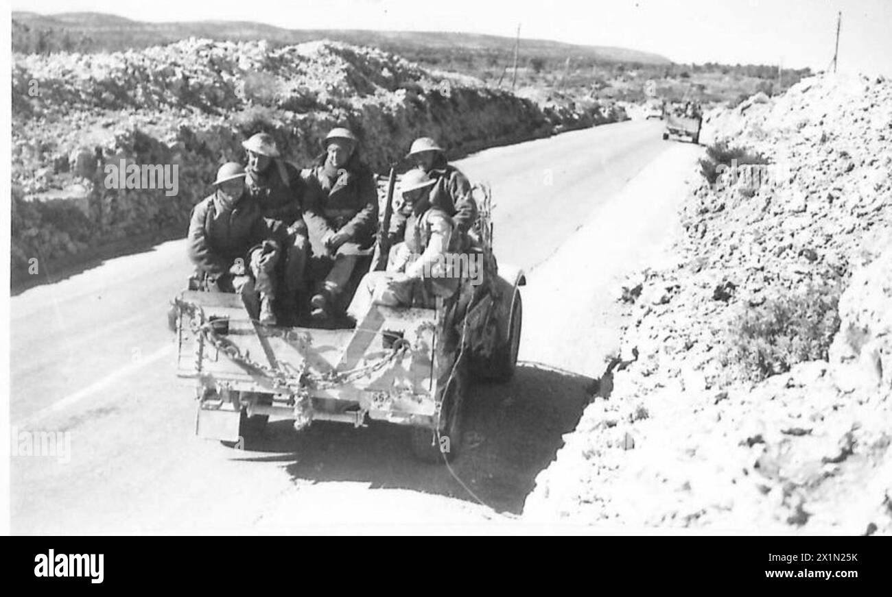 Des hommes et du matériel de l'armée britannique marchent le long des routes à travers le pays vert près de Derna, non plus dans le désert, avançant avec des fournitures et des véhicules. Banque D'Images