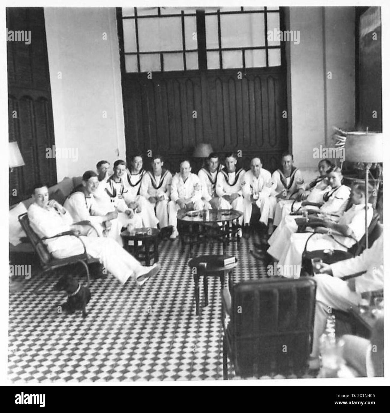 SAR El Emir Mansur ibn Saoud termine une visite pendant que l'escorte navale reçoit des boissons rafraîchissantes dans les bureaux de la Standard Oil Company à Djeddah. Banque D'Images