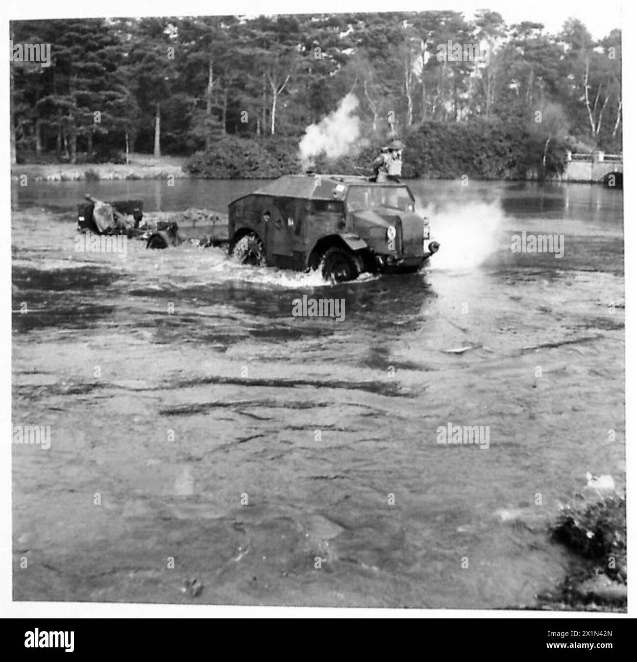 LES VÉHICULES DE L'ARMÉE NÉGOCIENT UNBRIDGED RIVER - Quad et 25-pounder canon étant conduit dans l'eau, British Army Banque D'Images