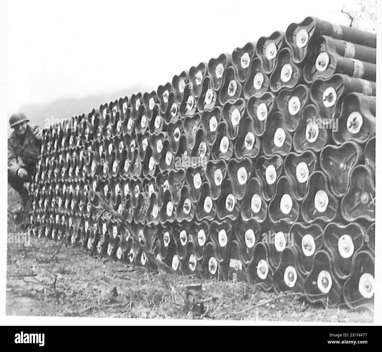 Le soldat Joseph Furmansky de Birmingham, Alabama, se tient à côté de bombes de mortier de 5 pouces dans un dépotoir de la Cinquième armée dans la région de Cassino, en Italie, armée britannique. Banque D'Images