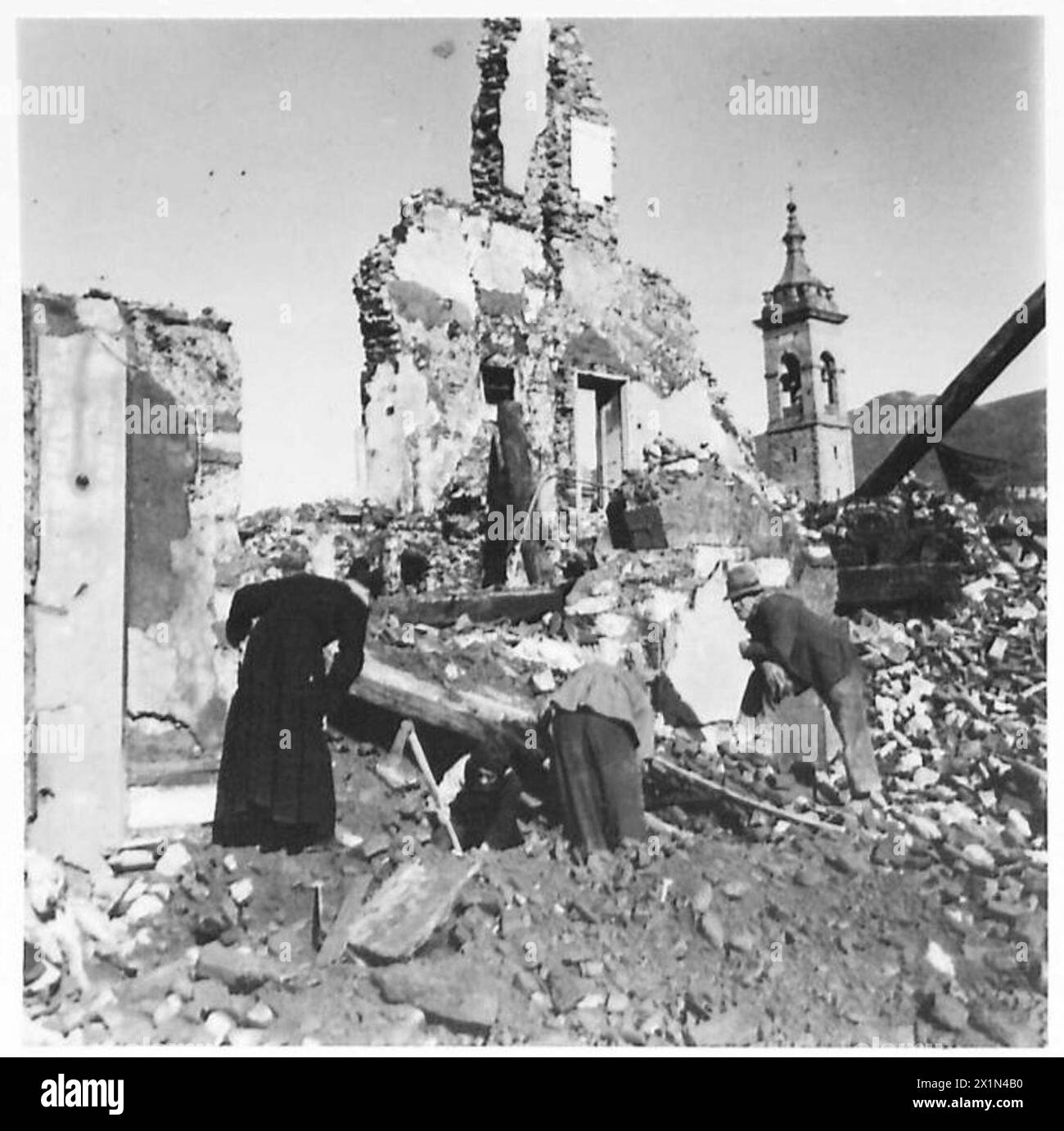 À Firenzuola, le curé de la paroisse supervise la récupération d'un fonts baptismaux du XIVe siècle et d'une peinture de Madonna Della Roario après le déblaiement des décombres, observé par le personnel de l'armée britannique. Banque D'Images