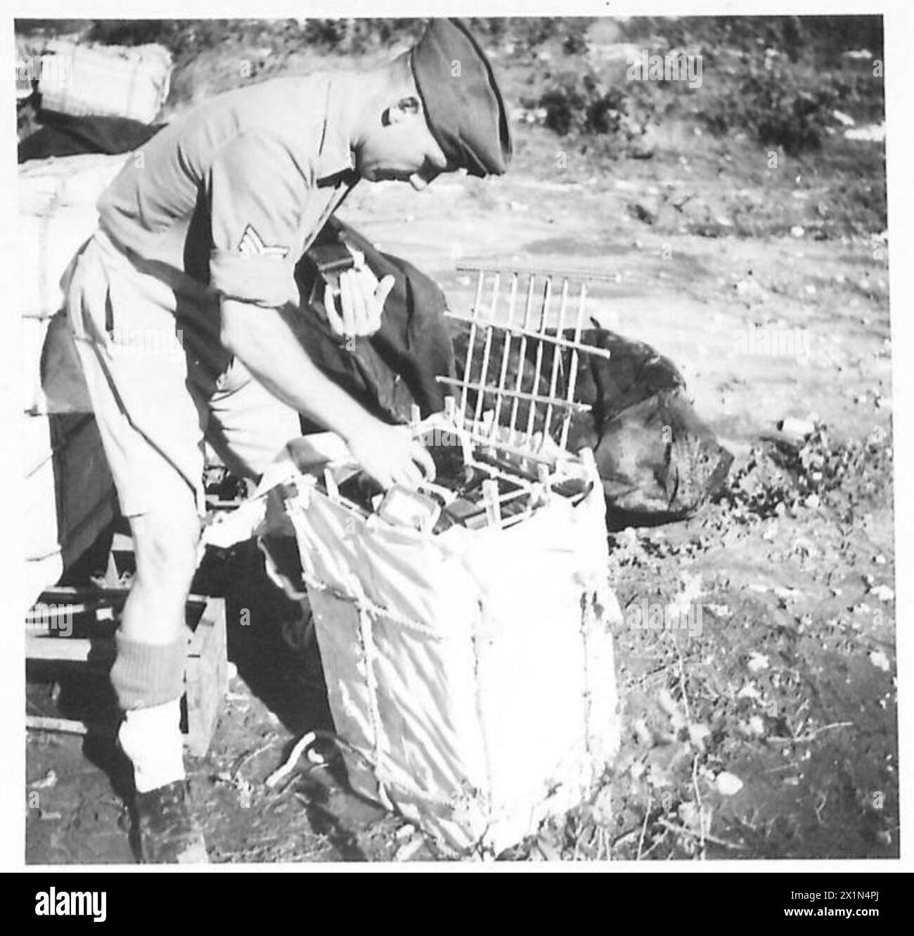 Le Sgt Purvis de Hull charge des boîtes de cartouches de signal dans un conteneur improvisé pendant l'entraînement parachutiste influencé par les leçons apprises en Hollande, armée britannique. Banque D'Images