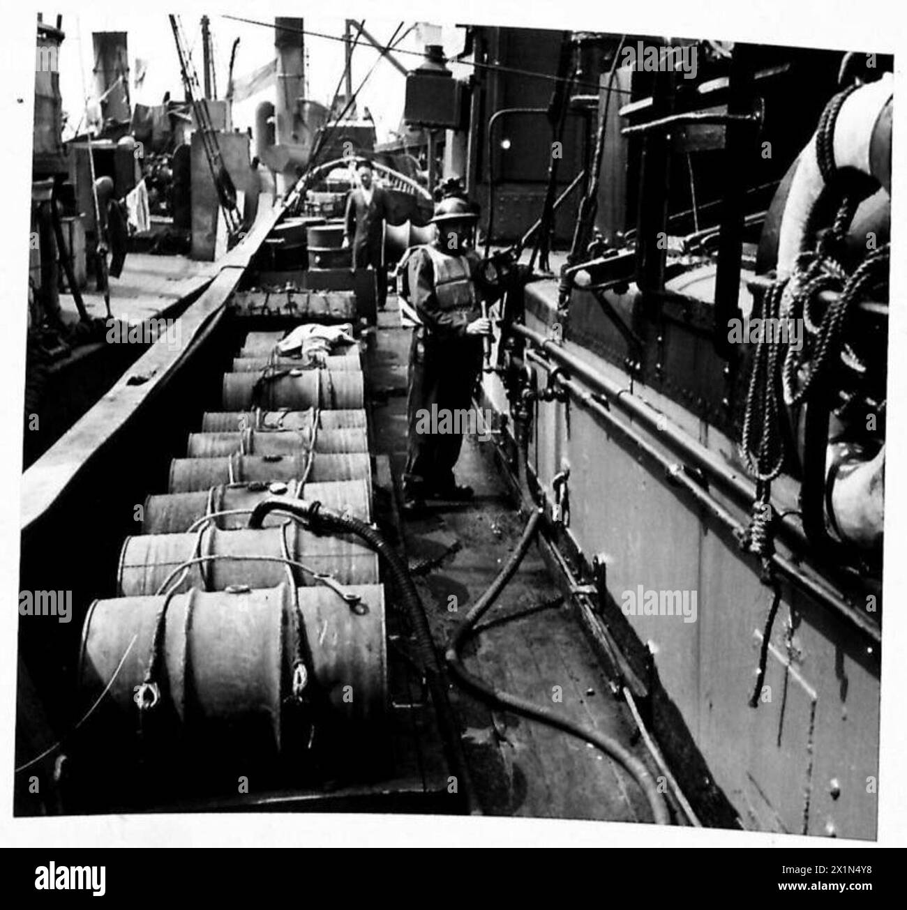 Les chalutiers sont équipés de générateurs de fumée tandis que le pétrole est pompé à partir de fûts à côté des navires, British Army. Banque D'Images