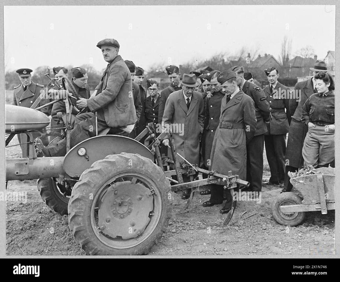Les aviateurs de la RAF reçoivent des instructions sur la campagne « Dig for Victory », en apprenant des exercices de position sur le tracteur International Farmall de H.H. Cook, 1943. Banque D'Images