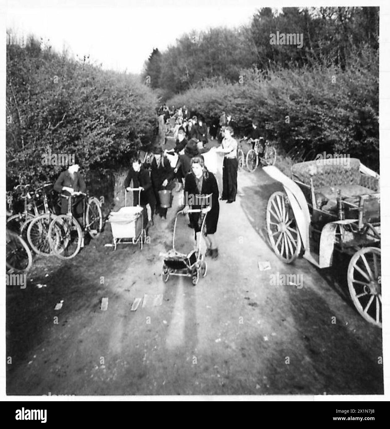 Des civils allemands et des esclaves européens ont pillé des barges sur un canal, prenant du fromage, du vin, de la graisse, de la farine, et du riz. La foule comprenait des travailleurs français, polonais, néerlandais et russes utilisant des vélos, des chevaux et des chariots pour transporter de la nourriture pendant les opérations de l'armée britannique avec le 21e groupe d'armées. Banque D'Images