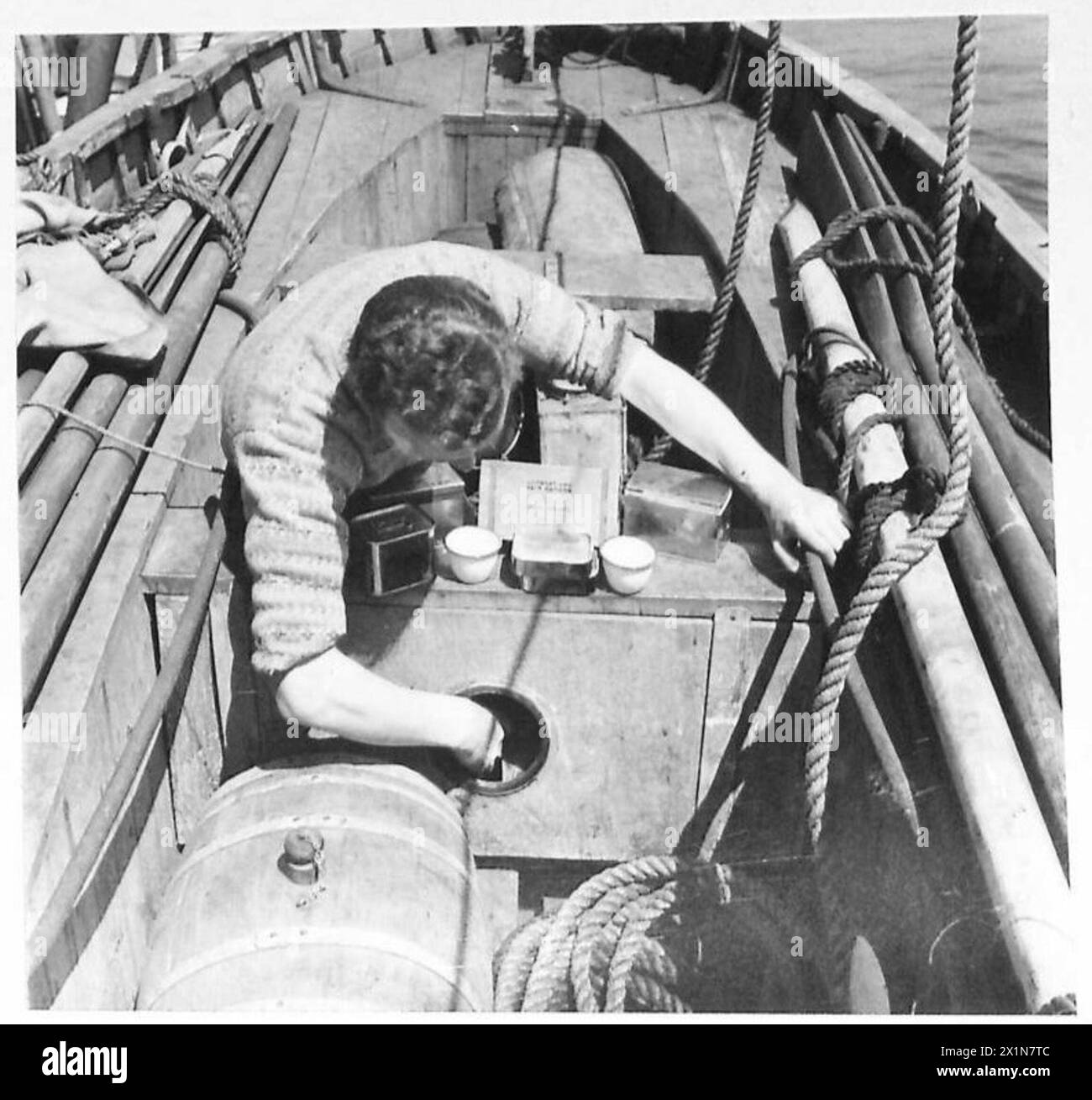 Le troisième officier S. Sutherland des Shetlands emballe des rations d'urgence dans des canots de sauvetage, maintenant l'équipement de sauvetage à bord d'un navire de convoi à destination de l'Afrique, l'armée britannique. Banque D'Images