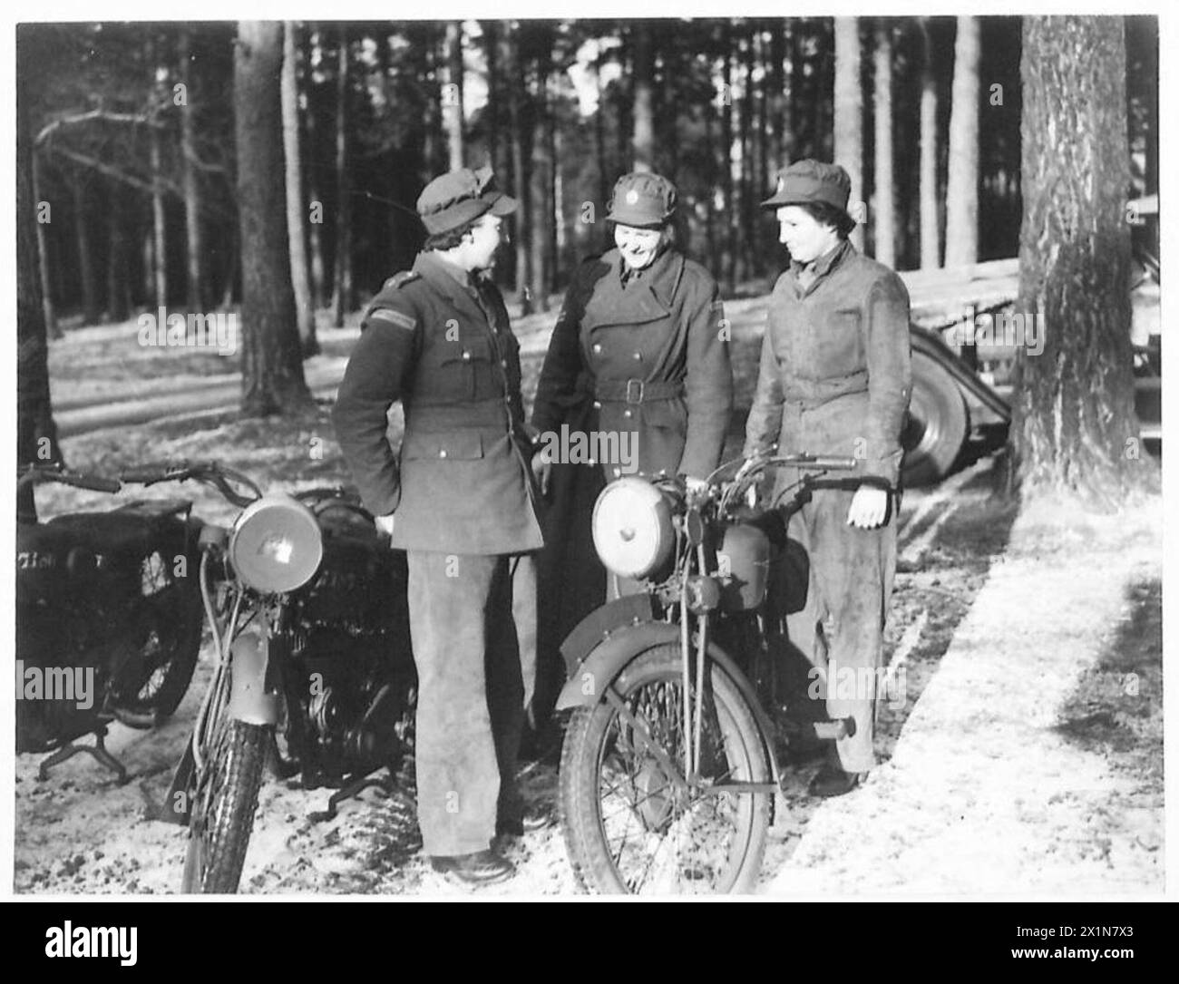 Les membres du Service territorial auxiliaire (A.T.S.) suivent une formation en motocyclette. Ils sont habillés dans des combinaisons de salopette remplaçables, soulignant la tenue pratique pour leurs séances d'entraînement. Banque D'Images