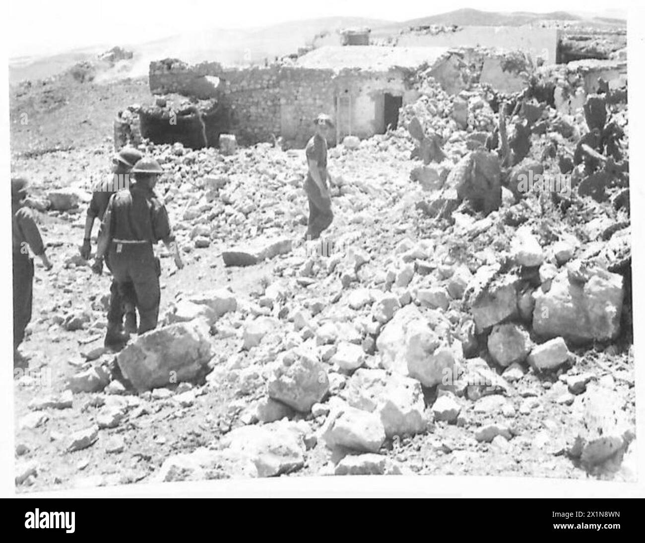 AVEC LA PREMIÈRE ARMÉE - après un violent assaut par artillerie et tirs de mortier, le village de montagne de Heidous est tombé aux mains des Inniskillings le dimanche de Pâques. Le village est un peu plus qu'un tas de ruines et ici le personnel de la RAMC fouille les restes des maisons à la recherche de blessés, l'armée britannique Banque D'Images