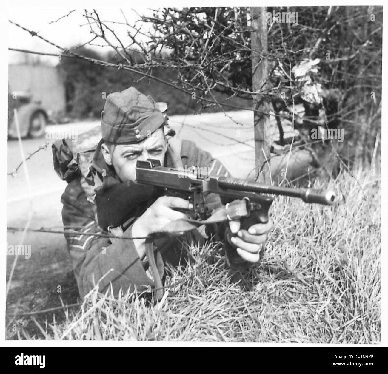Au cours d'un exercice divisionnaire en Écosse, un soldat de l'armée britannique simule les forces ennemies à l'aide d'un canon Tommy à des fins d'entraînement. Banque D'Images
