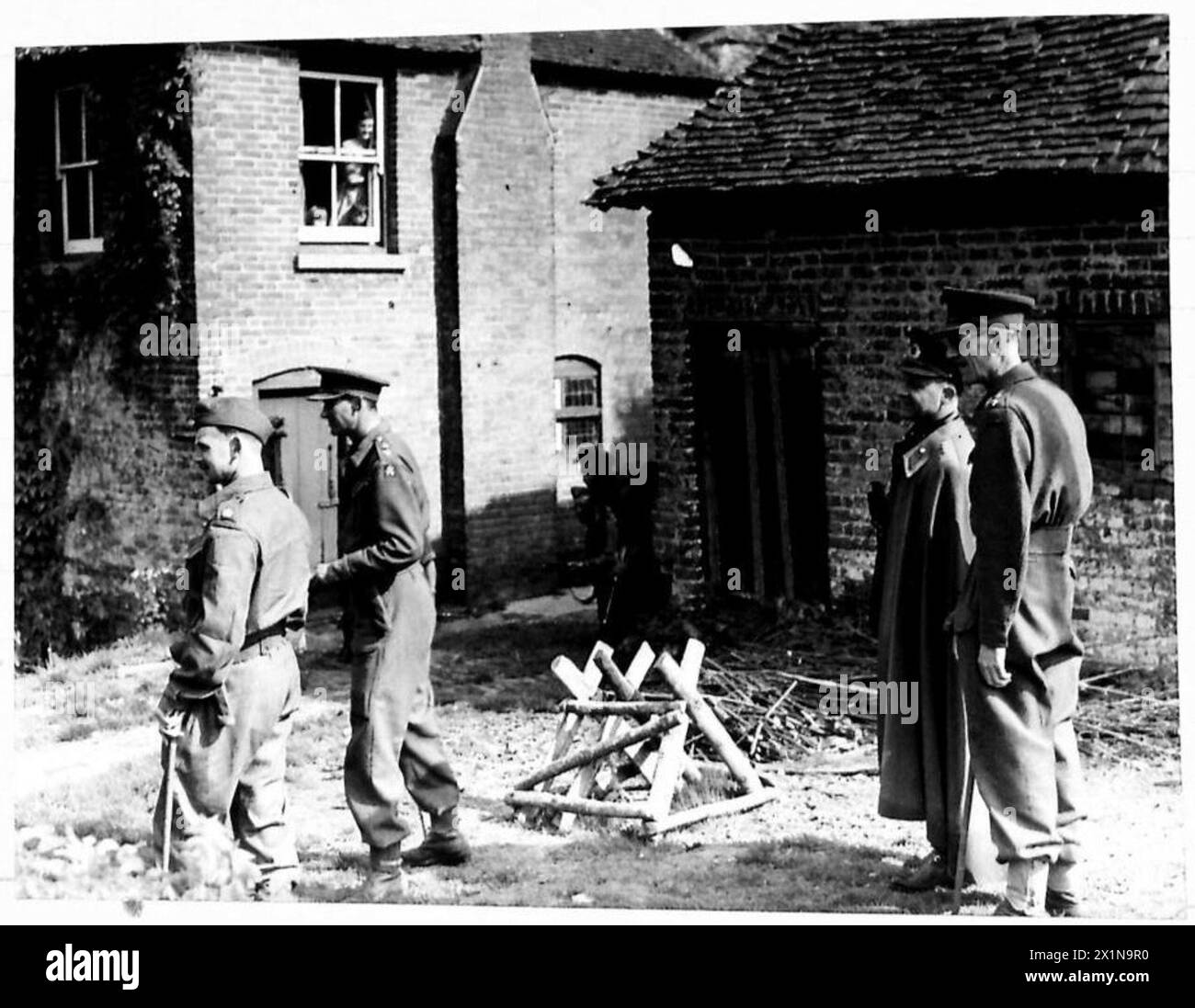 L'attaché militaire turc observe des soldats de l'armée britannique dans une école de bataille lors d'une simulation d'attaque dans une ferme, accompagnés d'officiers. Banque D'Images