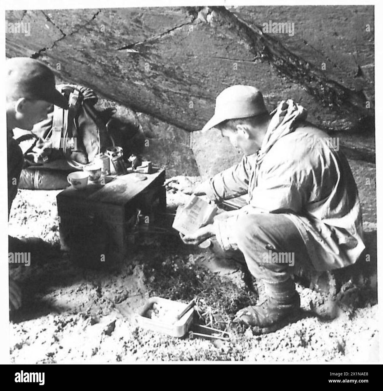 Les soldats connus sous le nom de Green Devils cuisinent en utilisant des cuisinières Tommy pendant une pause de l'armée britannique. Banque D'Images