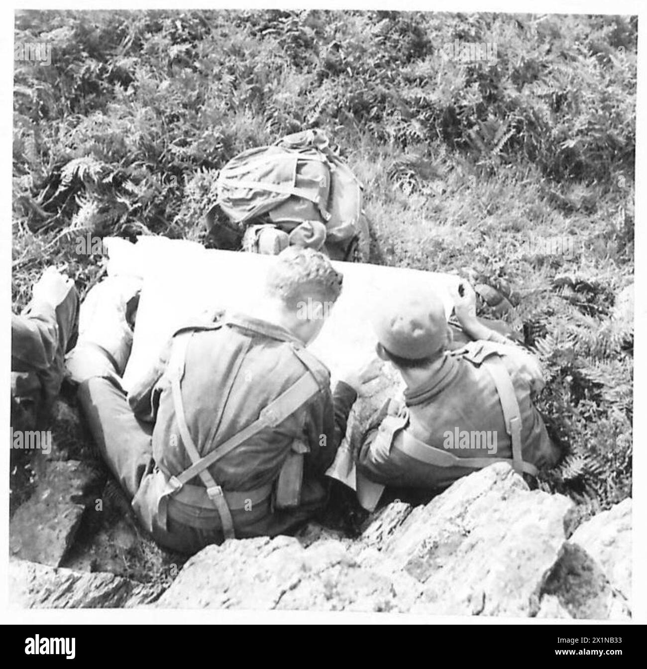 Les membres de l'unité de l'armée britannique « The Green Devils » étudient une carte pour planifier leur prochaine opération lors d'une pause déjeuner. Banque D'Images