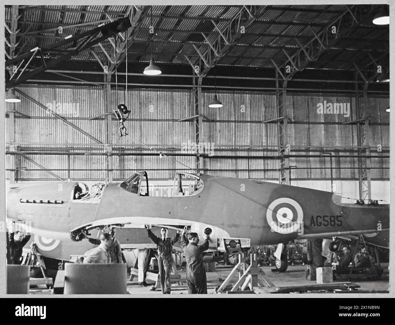 ASSEMBLAGE D'AVIONS MUSTANG des États-Unis AU ROYAUME-UNI - (photo publiée en 1942) la grue lève le fuselage du plancher de l'affaire, Royal Air Force Banque D'Images