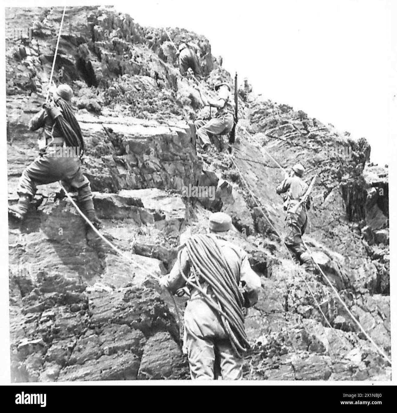 Une unité de l'armée britannique connue sous le nom de « Devils verts » est montrée en train de négocier une fissure et d'escalader une falaise accidentée lors d'un exercice militaire. Banque D'Images