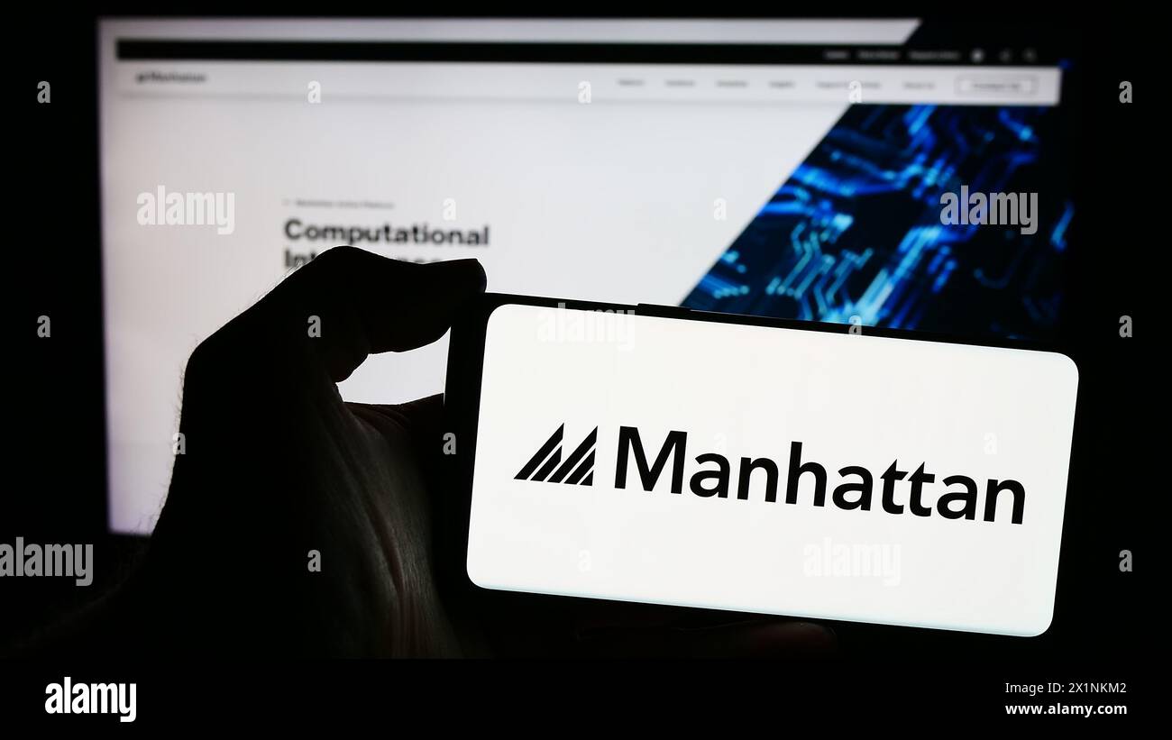 Personne tenant un smartphone avec le logo de la société américaine de logiciels Manhattan Associates Inc en face du site Web. Concentrez-vous sur l'affichage du téléphone. Banque D'Images
