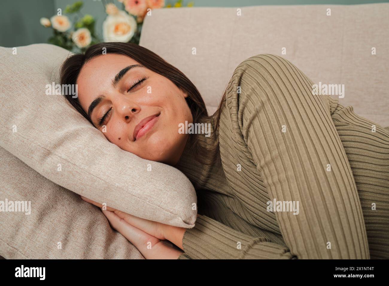 Jeune femme caucasienne endormie faisant la sieste sur le canapé pendant la journée. Sieste féminine épuisée au canapé du salon, ayant un bon rêve avec une expression positive. Dame paresseuse se reposant à la maison. Photo de haute qualité Banque D'Images