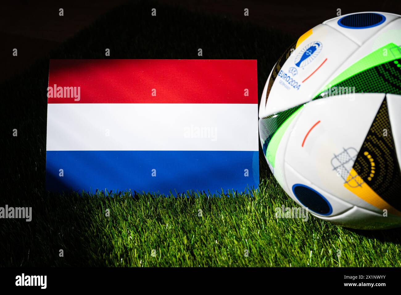 HAMBOURG, ALLEMAGNE, 17 AVRIL 2024 : drapeau national des pays-Bas et ballon officiel de football de l'Euro 2024 en Allemagne placé sur l'herbe verte Banque D'Images