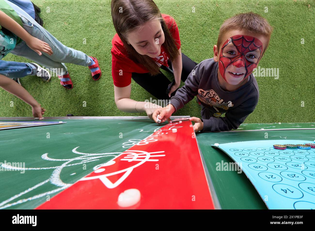 Bucarest, Roumanie. 17 avril 2024 : un garçon ukrainien joue avec un bénévole lors de l'ouverture du Centre de jour pour les enfants réfugiés d'Ukraine dont les mères travaillent ou veulent trouver un emploi. Le centre est ouvert par la Fondation Save the Children Roumanie pour 40 enfants, âgés de 6 à 11 ans, et pour soutenir les mères réfugiées d'Ukraine afin qu'elles puissent laisser leurs enfants en toute sécurité pendant qu'elles sont au travail, compte tenu du fait que trois parents ukrainiens sur cinq ne pouvaient pas trouver d'emploi en Roumanie, la plupart d'entre eux invoquant la barrière de la langue ou la nécessité de s'occuper d'un membre de la famille. Depuis l'outbr Banque D'Images