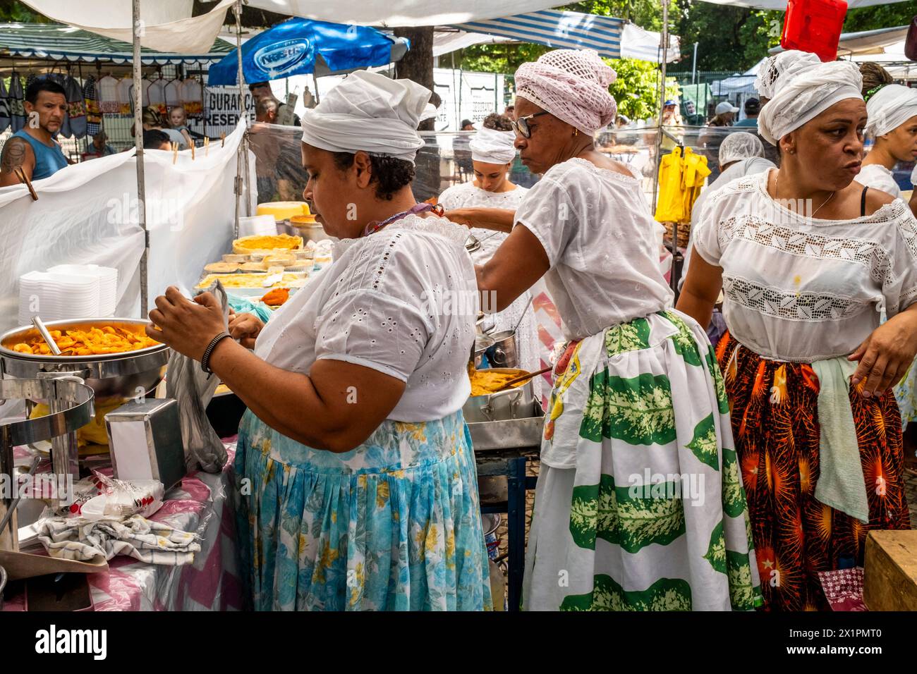 Femmes brésiliennes en costume traditionnel cuisiner et préparer la nourriture dans Un café au marché du dimanche d'Ipanema (foire hippie), Rio de Janeiro, Brésil Banque D'Images