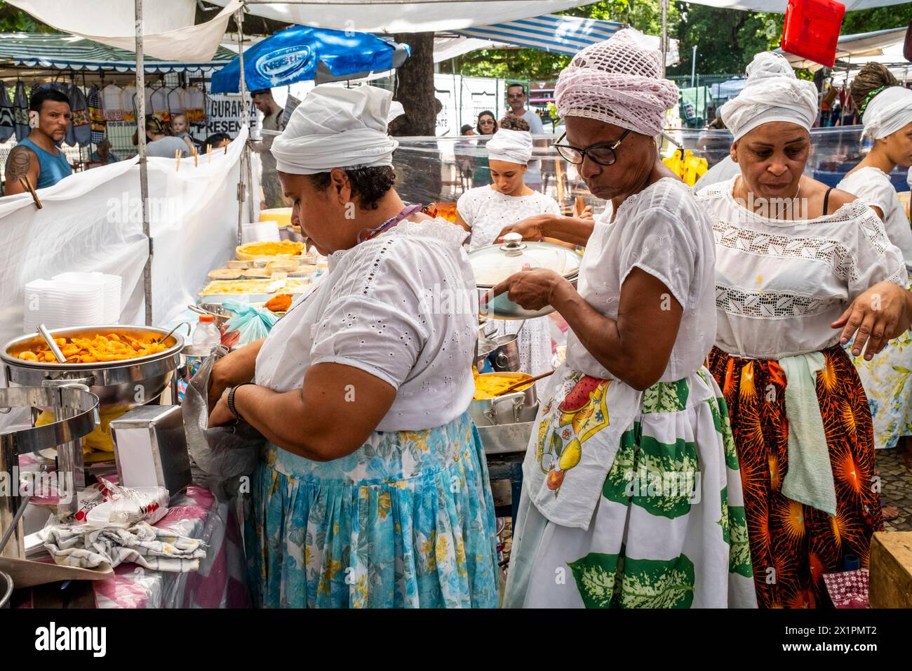 Femmes brésiliennes en costume traditionnel cuisiner et préparer la nourriture dans Un café au marché du dimanche d'Ipanema (foire hippie), Rio de Janeiro, Brésil Banque D'Images