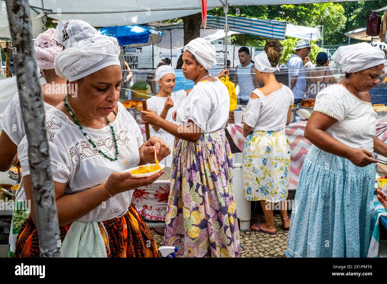 Femmes brésiliennes en costume traditionnel cuisiner et préparer la nourriture dans Un café au marché du dimanche d'Ipanema (foire hippie), Rio de Janeiro, Brésil. Banque D'Images