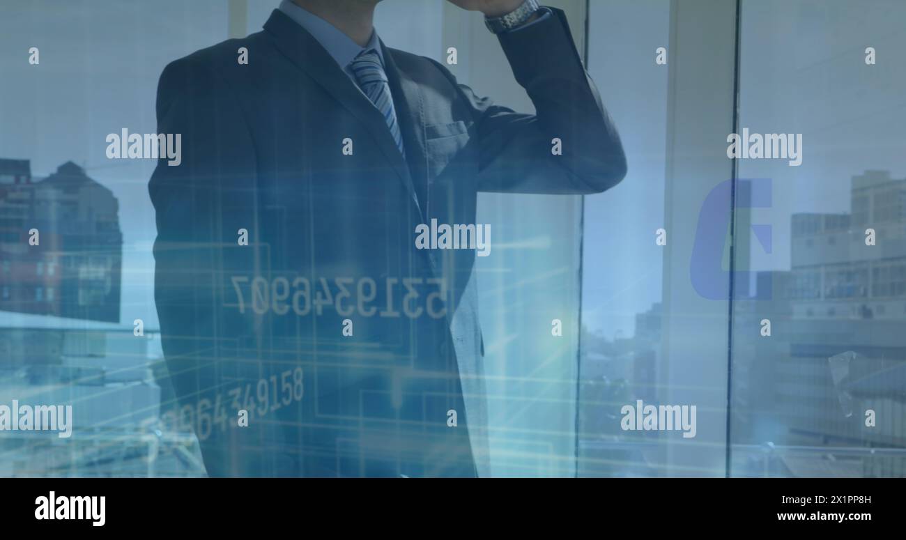 Collègue masculin caucasien portant un costume debout près de la fenêtre Banque D'Images