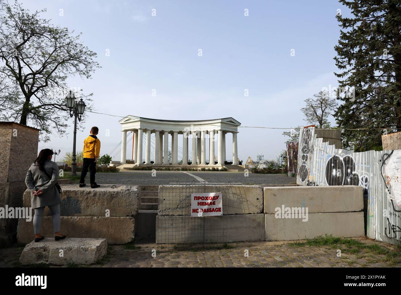 Odessa, Ukraine. 17 avril 2024. Une femme avec un enfant se tient à la clôture en béton limitant le passage à la Colonnade Vorontsov au bout du boulevard Prymorskyi. Le palais Vorontsov est un palais et une colonnade du XIXe siècle à Odessa, en Ukraine, au bout de la passerelle piétonne du boulevard Prymorskyi est fermée au public depuis le début de l'invasion à grande échelle de la Fédération de Russie sur le territoire de l'Ukraine. Crédit : SOPA images Limited/Alamy Live News Banque D'Images