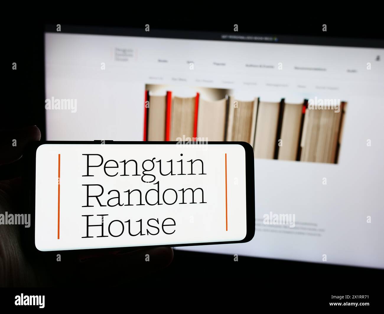 Personne tenant un smartphone avec le logo de la société d'édition américaine Penguin Random House en face du site Web. Concentrez-vous sur l'affichage du téléphone. Banque D'Images