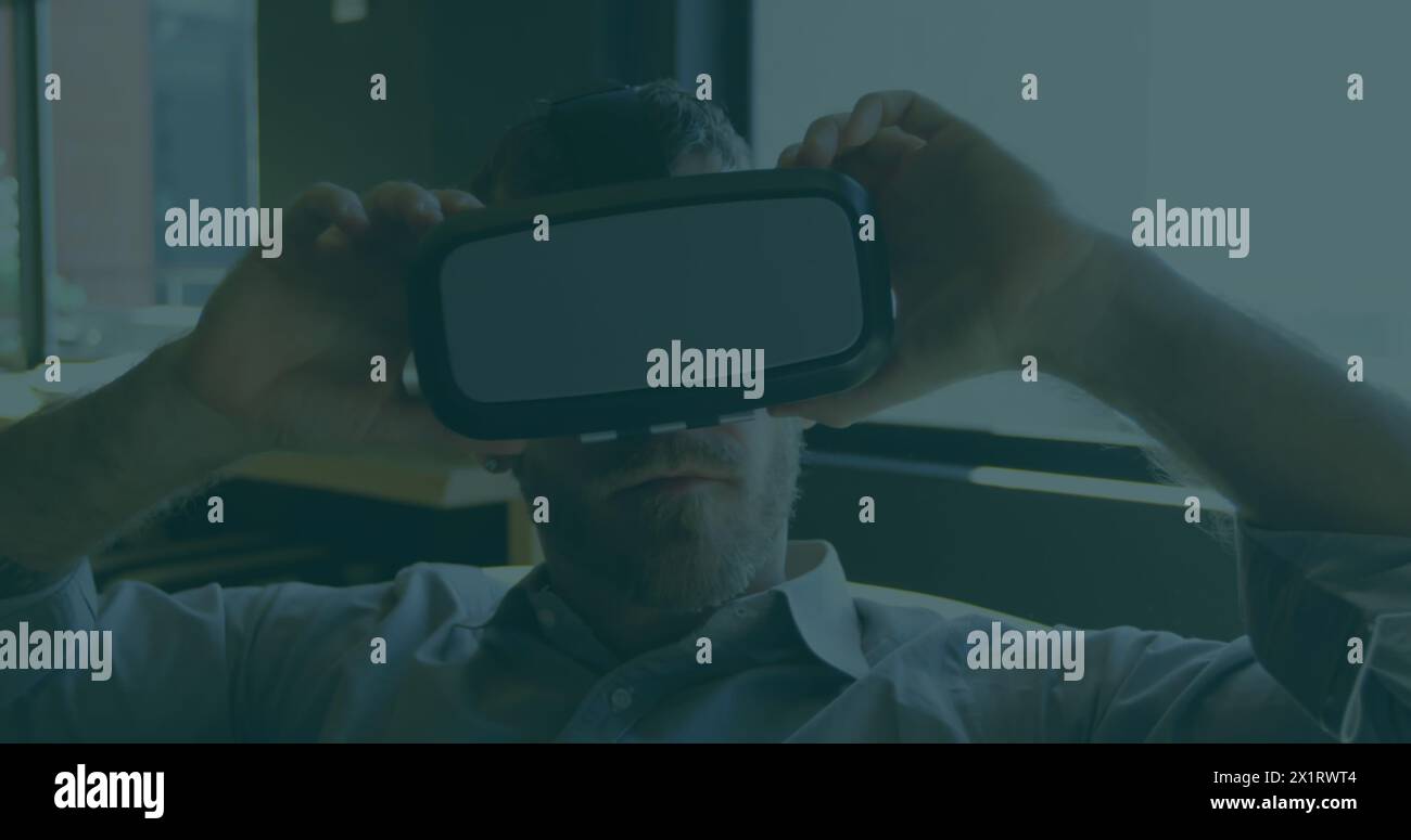 Homme caucasien d'âge moyen portant un casque de réalité virtuelle Banque D'Images