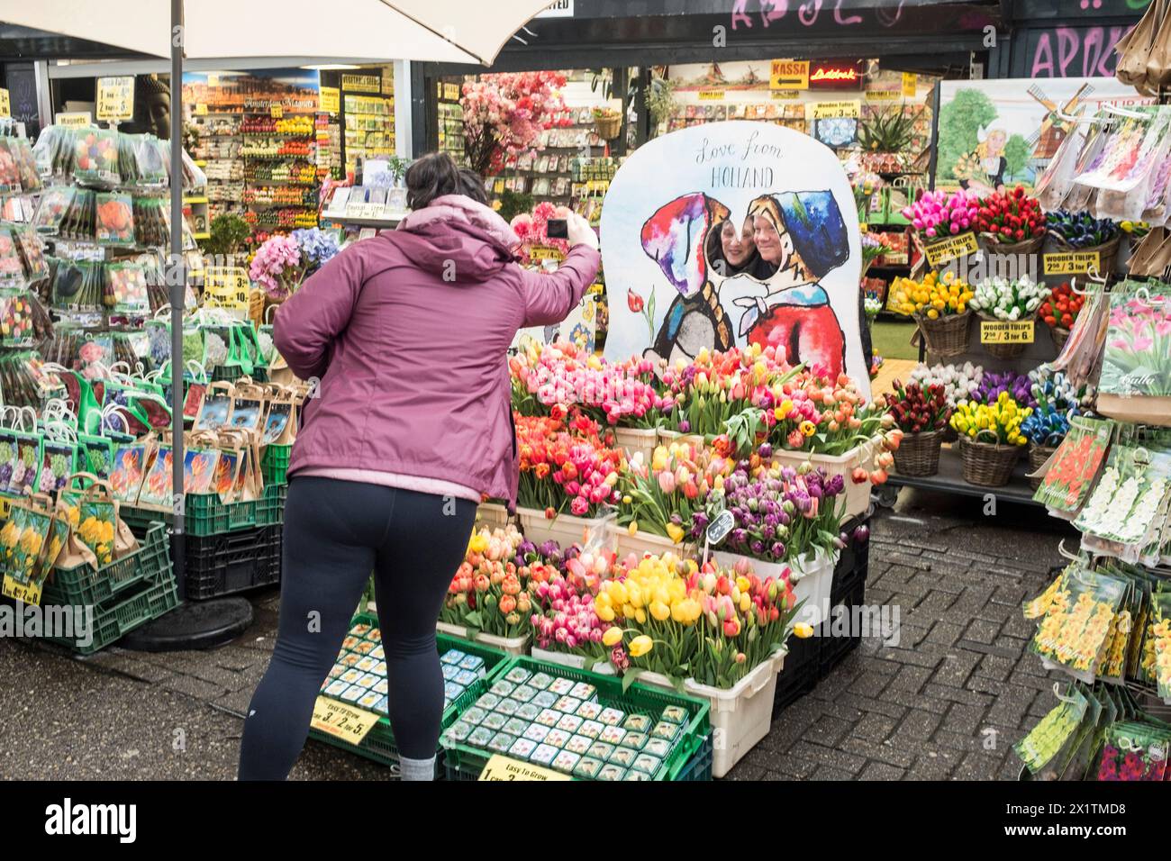 Les touristes ont leur photo prise au marché aux fleurs flottant coloré, Bloemenmarkt, sur le Singel dans le centre d'Amsterdam, aux pays-Bas Banque D'Images