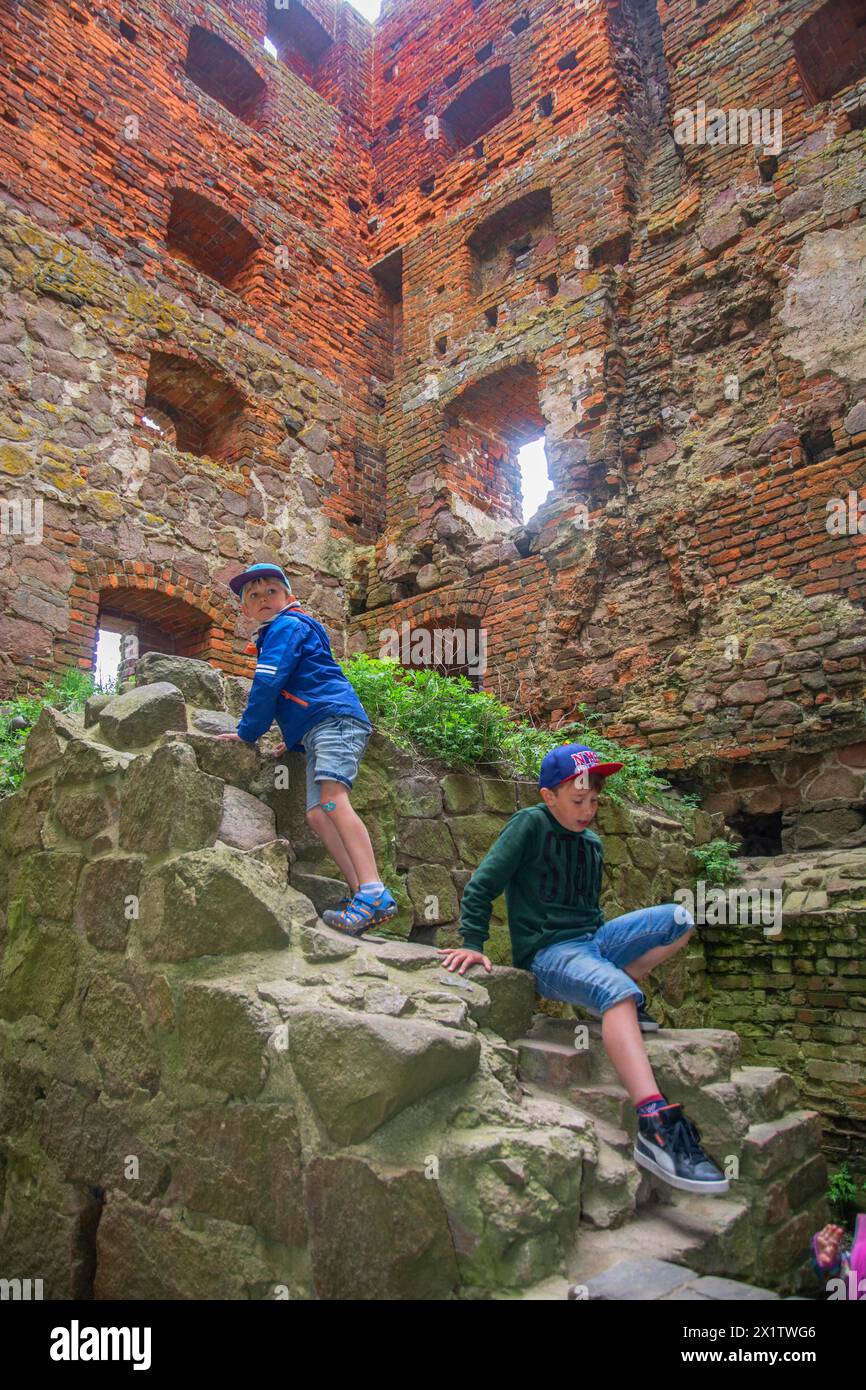 Deux garçons grimpant dans la tour de Hammershus qui était la plus grande fortification médiévale de Scandinavie et est l'une des plus grandes fortifications médiévales Banque D'Images