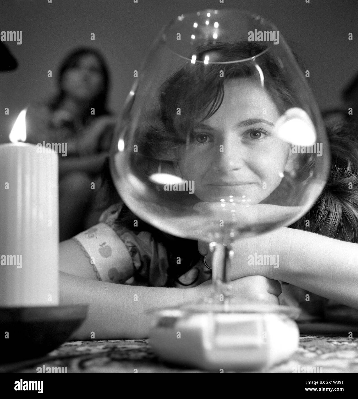 Roumanie, approx. 1975. Portrait d'une femme à travers un verre à vin. Banque D'Images