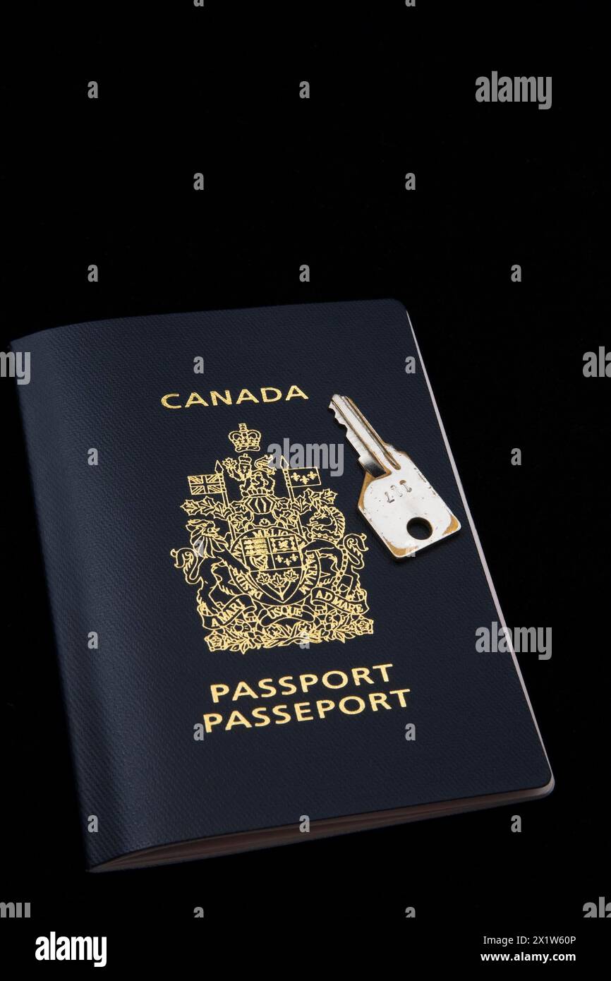 Gros plan de la clé chromée sur le dessus du passeport canadien sur fond noir, Studio composition, Québec, Canada Banque D'Images