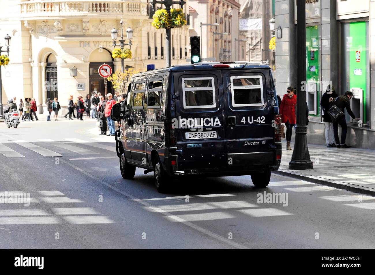 Grenade, véhicule de police dans une rue animée de la ville avec des piétons et des magasins, Andalousie, Espagne, Europe signe de rue en céramique de la Banque D'Images
