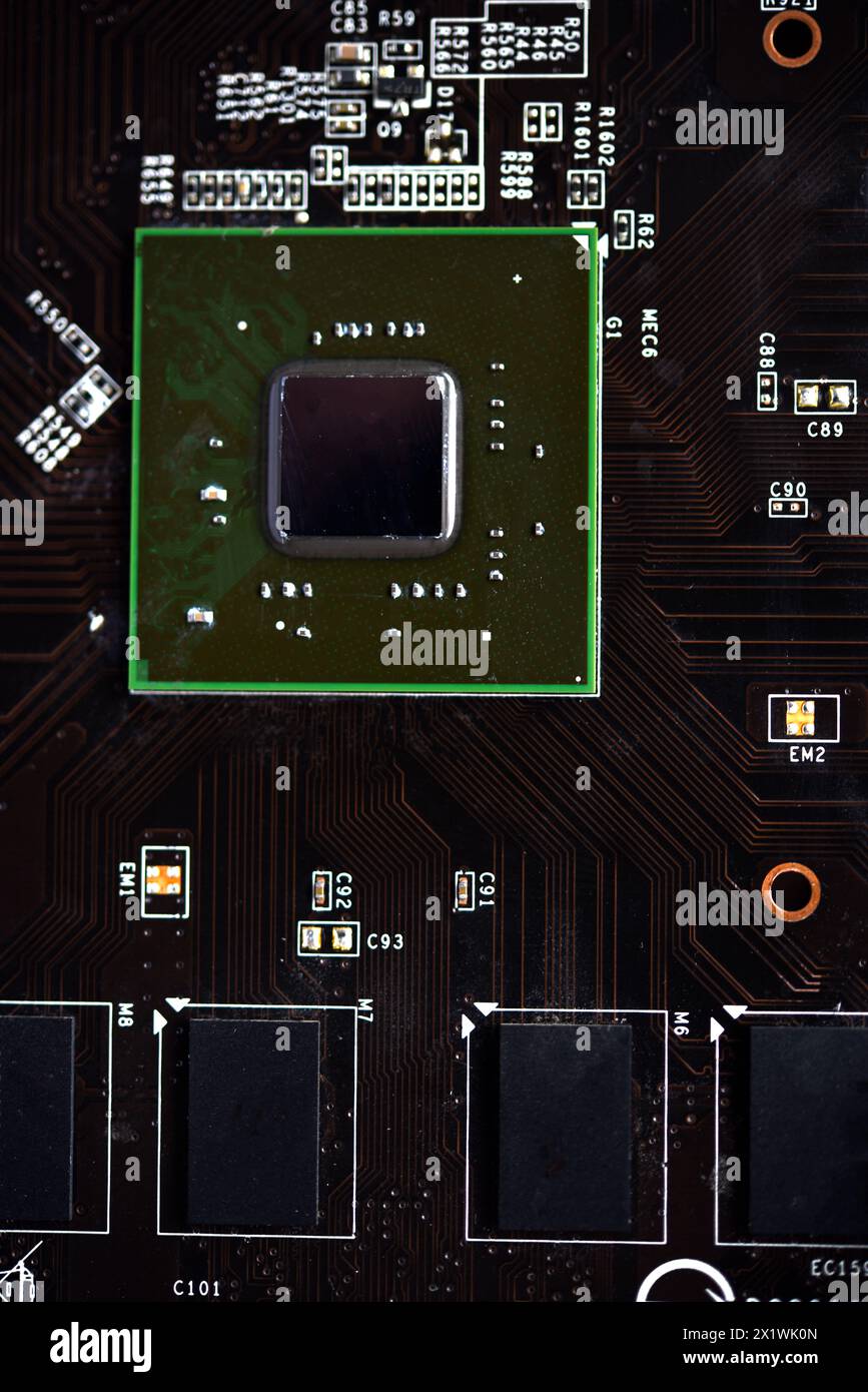 Une carte de circuit imprimé marron avec une puce de processeur et des bandes de mémoire vidéo. Composants électroniques sur la carte graphique. Banque D'Images