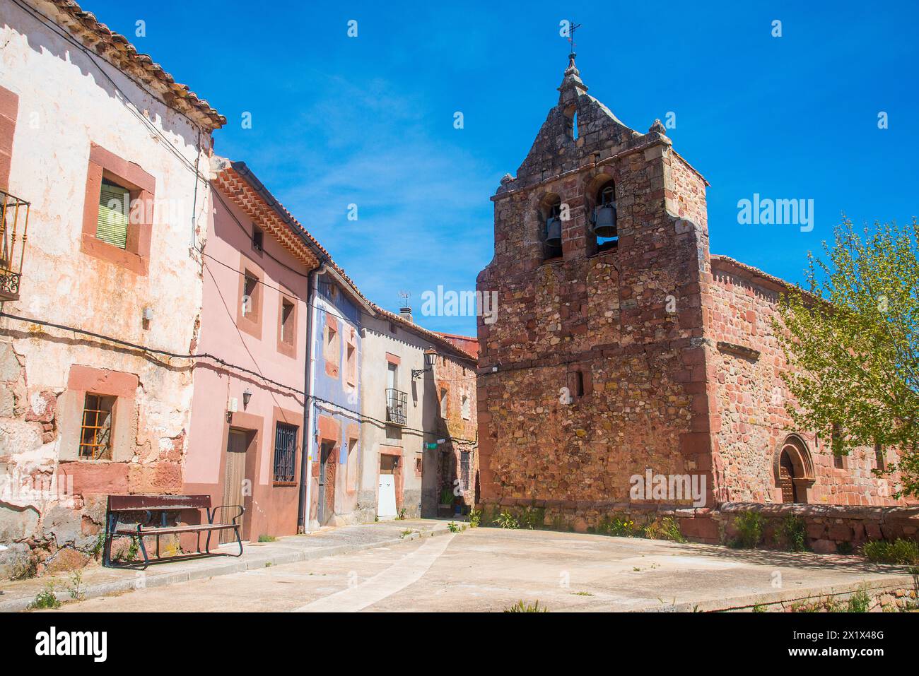 Rue et église. Riba de Santiuste, province de Guadalajara, Castilla la Mancha, Espagne. Banque D'Images