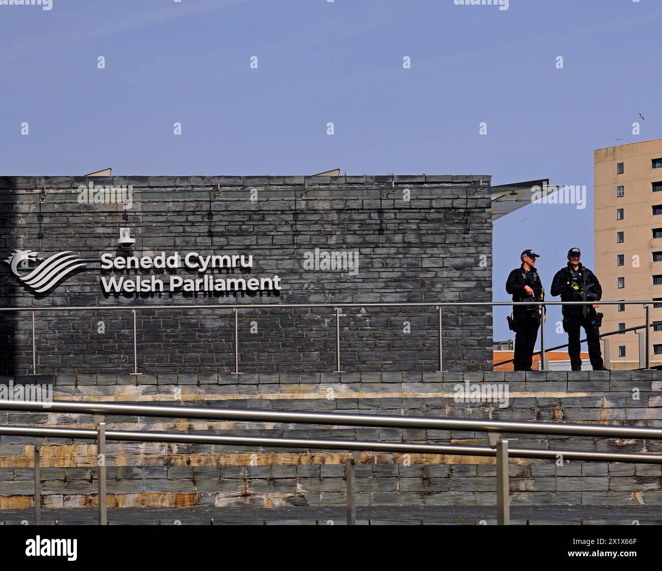 Bâtiment du Parlement gallois avec deux policiers armés gardant l'entrée. Prise en avril 2024 Banque D'Images