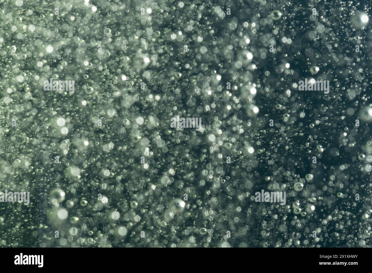 Gouttes d'eau dans l'air sur un fond bokeh foncé Banque D'Images