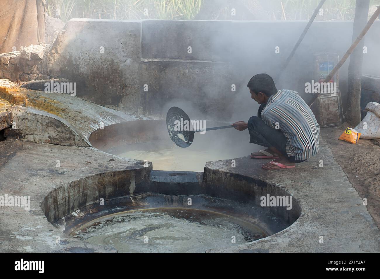 Obtenir du sucre en faisant bouillir le jus de canne à sucre pressé, Bihar, Inde Banque D'Images