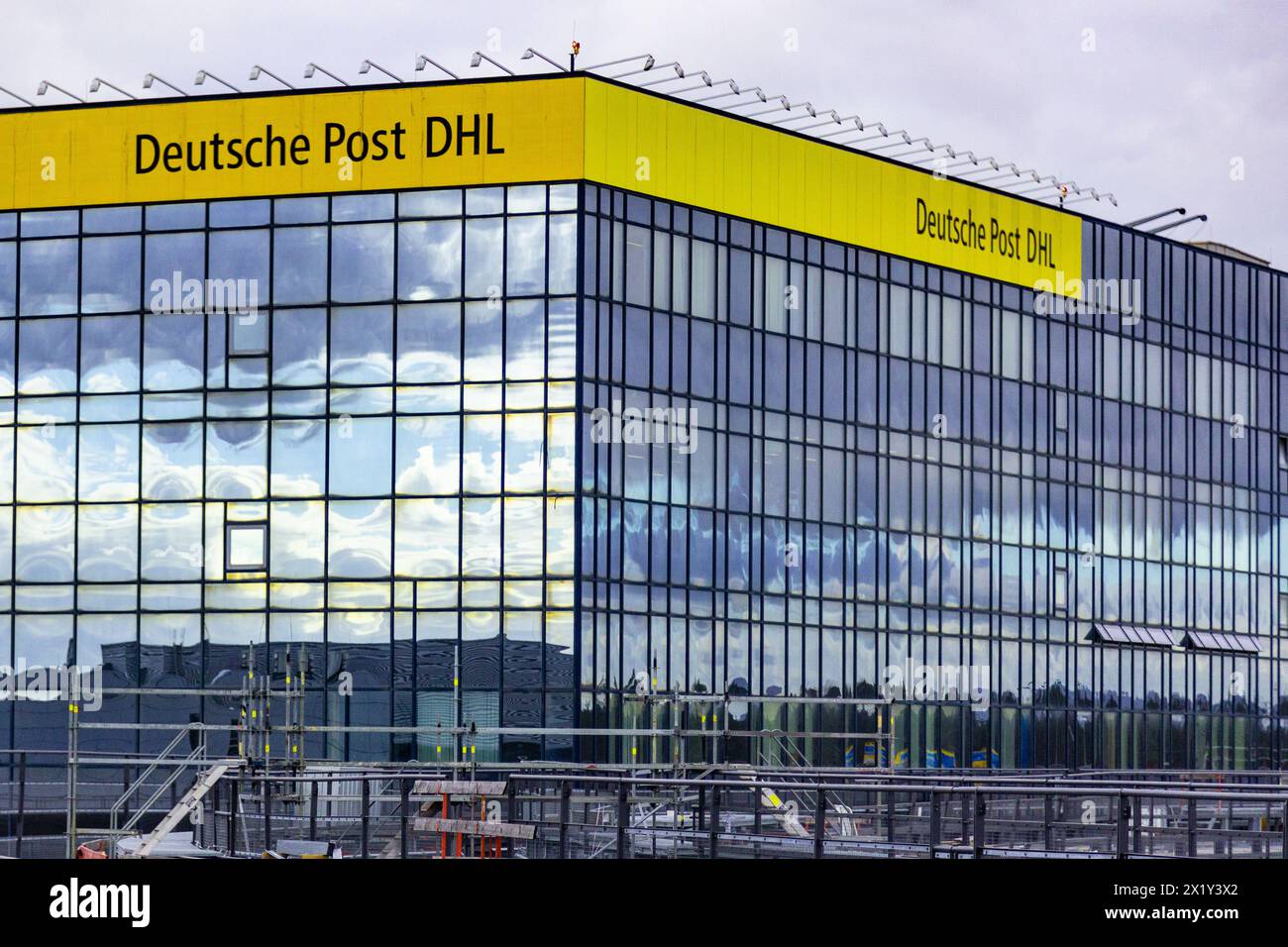 Aéroport international de Francfort, Allemagne - 19 février 2024 : la marque 'Deutsche Post DHL' sur un bâtiment avec une façade réfléchissante au Frankfurt in Banque D'Images