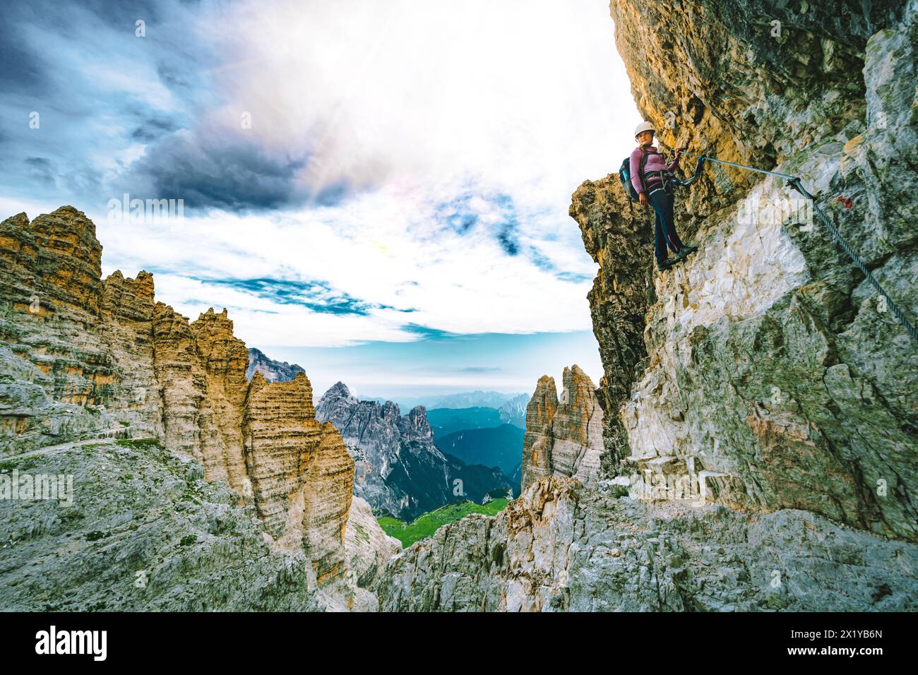 Description : jeune femme athlétique fait des randonnées dans la via ferrata dans la soirée. Tre Cime, Dolomites, Tyrol du Sud, Italie, Europe. Banque D'Images