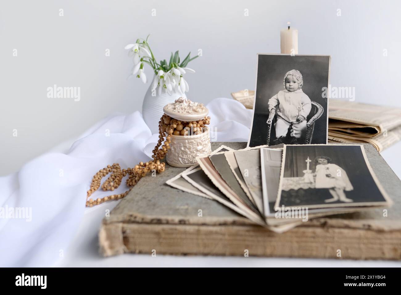 pile de photos vintage, images d'enfants de la première communion de 1950, bougie allumée, fleurs de printemps dans un vase, concept d'arbre généalogique, généalogie, ch Banque D'Images