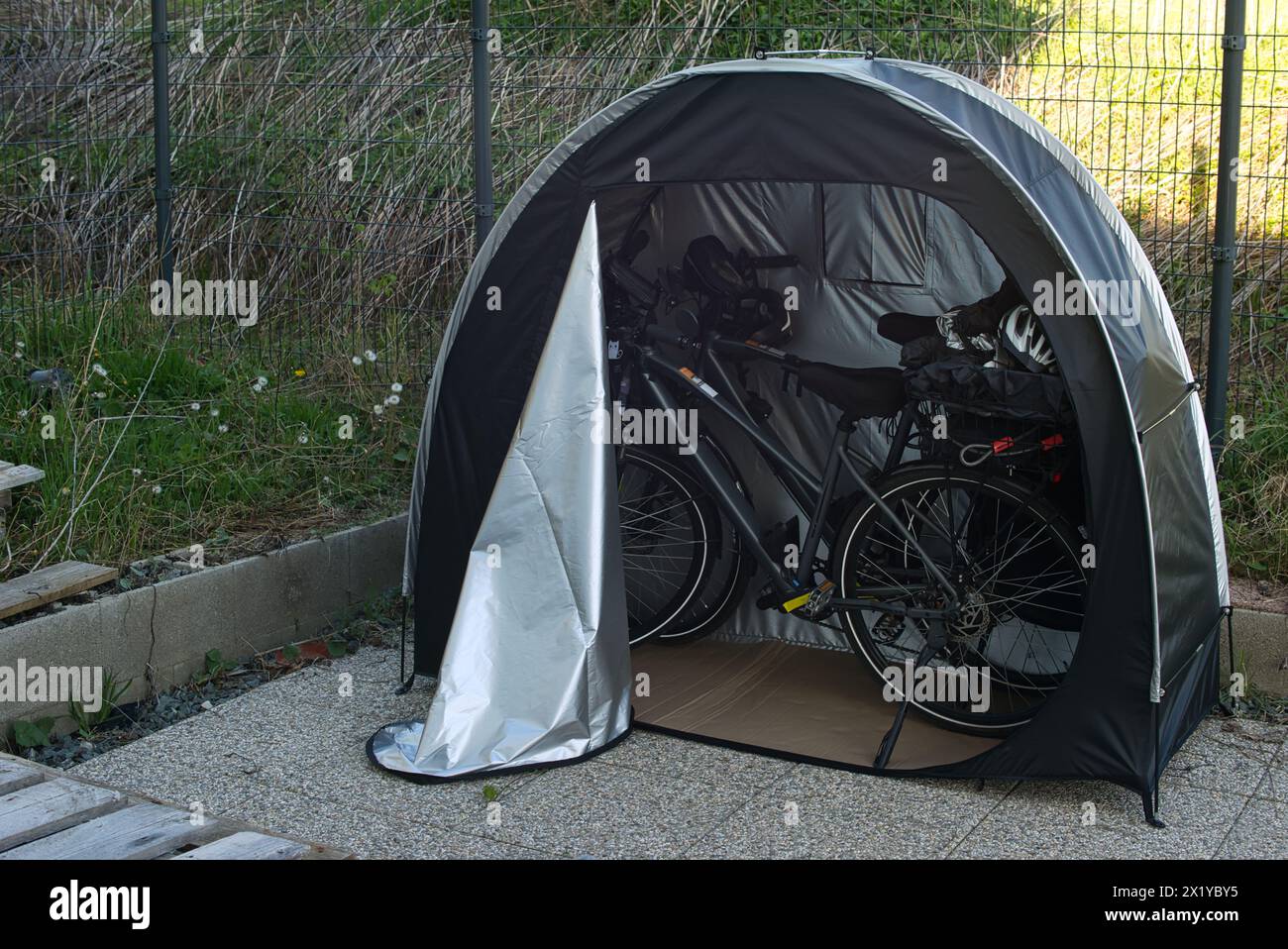 Tente de bicyclette abritant deux vélos électriques dans une enceinte extérieure. Contexte : stockage de vélos, sécurité des vélos, place de parking, tour à vélo, protection des vélos, excur Banque D'Images