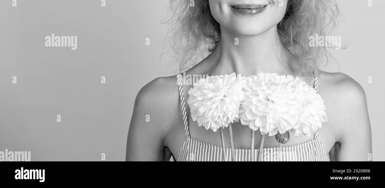 femme avec des fleurs de chrysanthème de jour de femme. femme avec des fleurs de jour pour femmes isolées sur jaune. femme avec des fleurs de jour de femme en studio. femme avec wom Banque D'Images