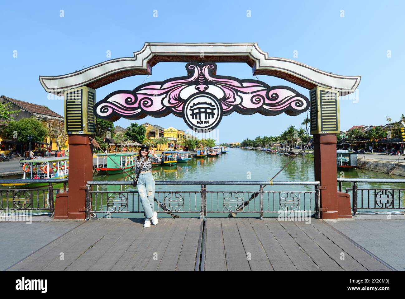 Un touriste posant pour une photo sur le pont an Hoi à Hoi an, Vietnam. Banque D'Images